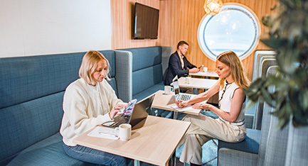 Three people working on laptops in the M/S Finlandia Lounge.