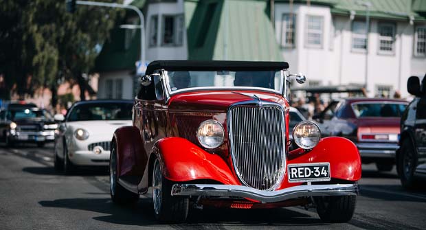 Red hot rod car on the road.