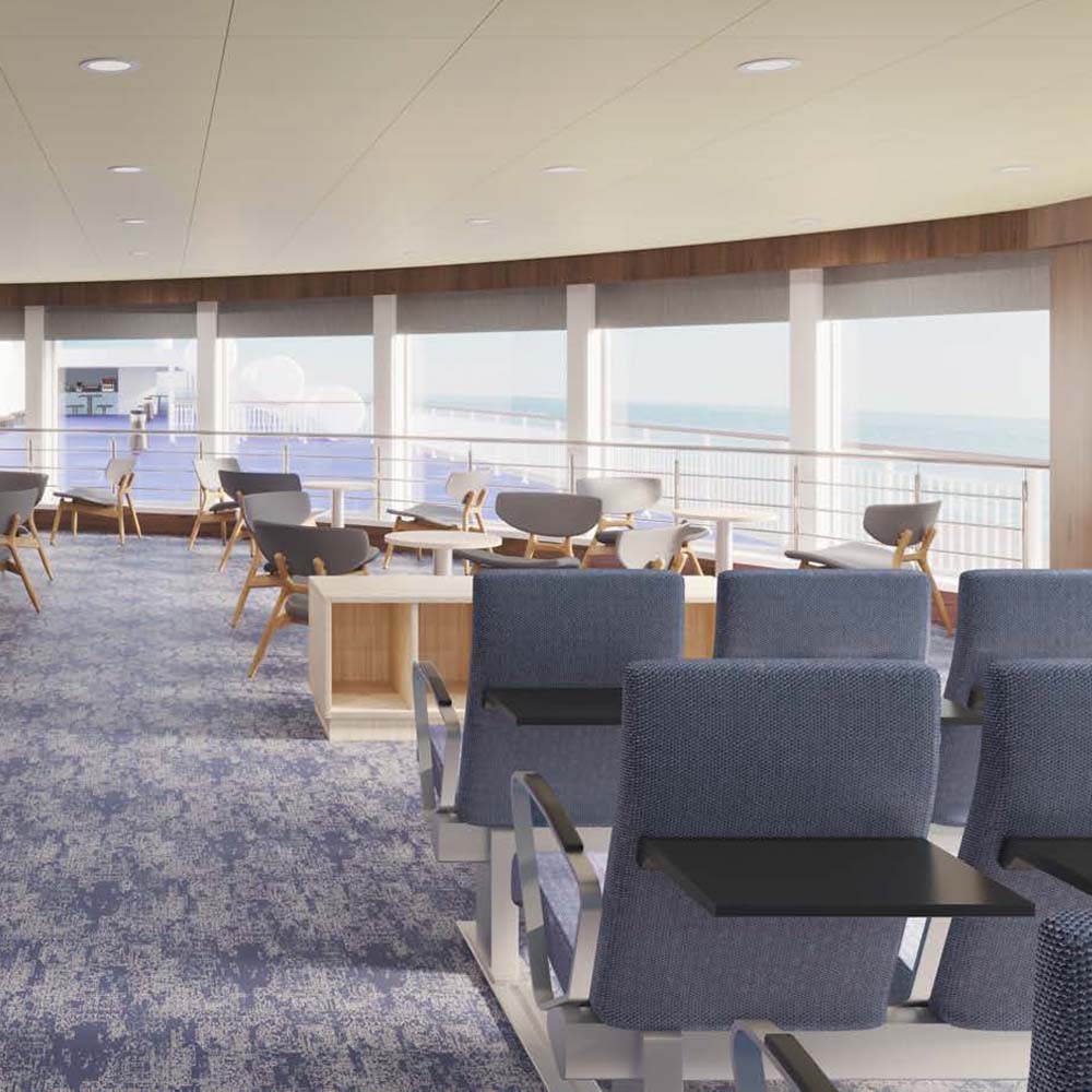 A row of seats on a ship. The windows offer a view of the sea.