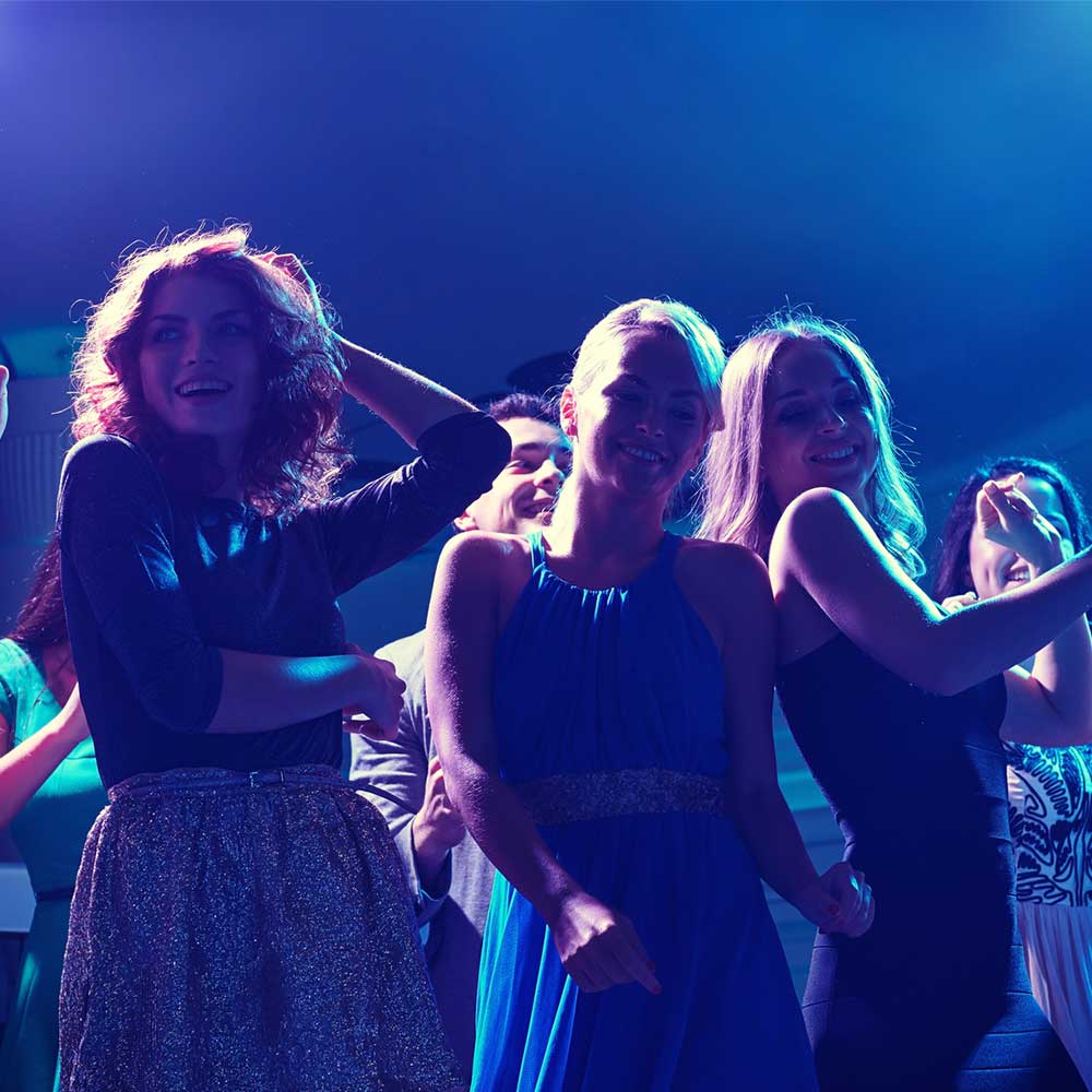 Three women enjoying them on the dancefloor.