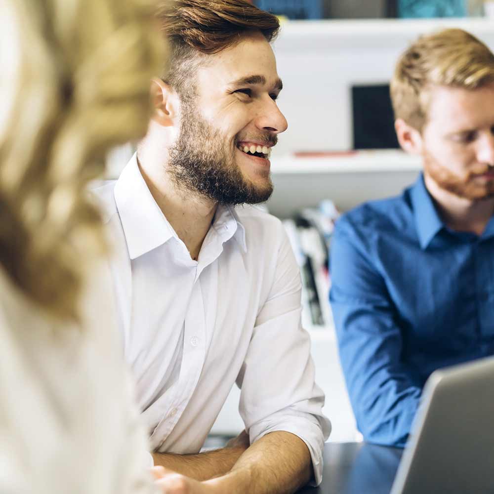 Smiling man in a white shirt in a conference.