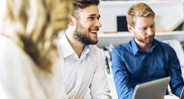 Smiling man in a white shirt in a conference.