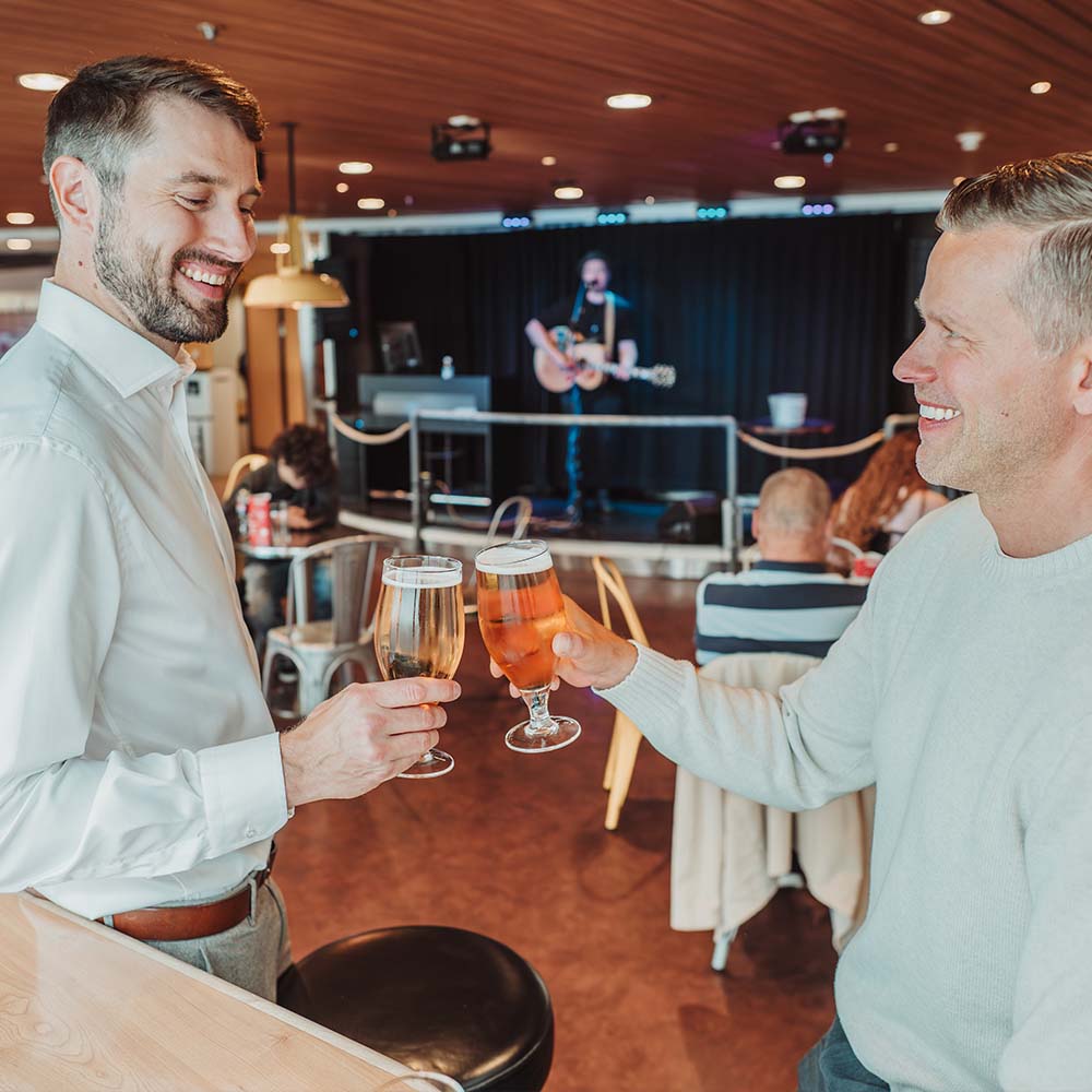 Two men enjoying sea voyage with a beer. Two men enjoying sea voyage with a beer.