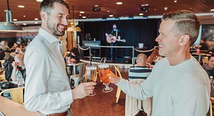 Two men enjoying sea voyage with a beer. Two men enjoying sea voyage with a beer.
