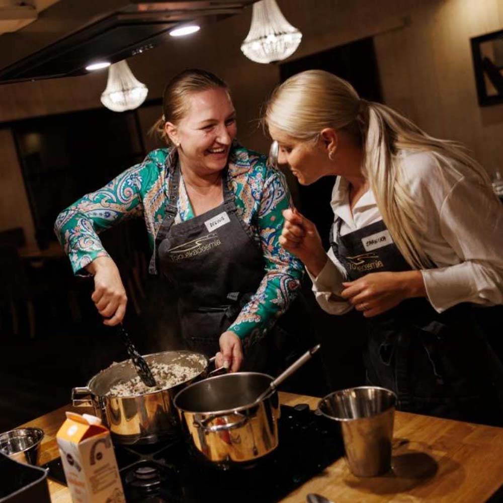 Two women laughing and cooking