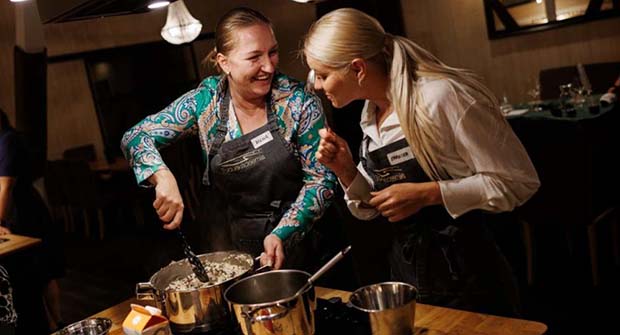 Two women laughing and cooking