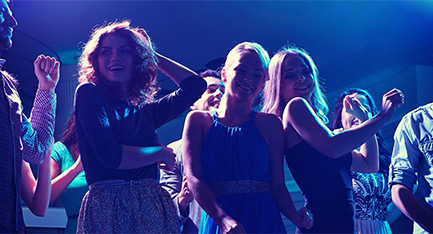 Three women enjoying them on the dancefloor.